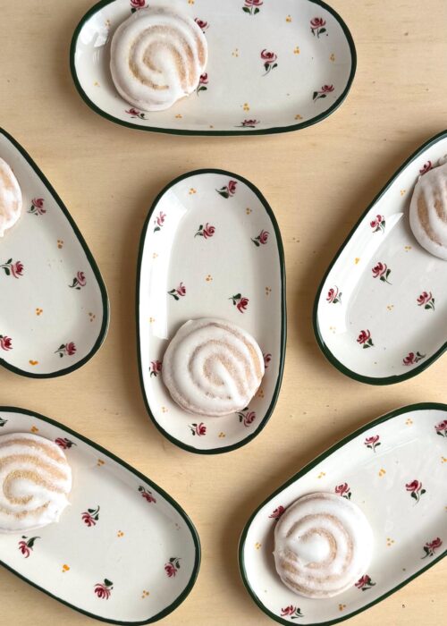 Close-up of Dalia Floral handpainted ceramic biscuit plate showing delicate pink and green floral design, artisan-made in Portugal.