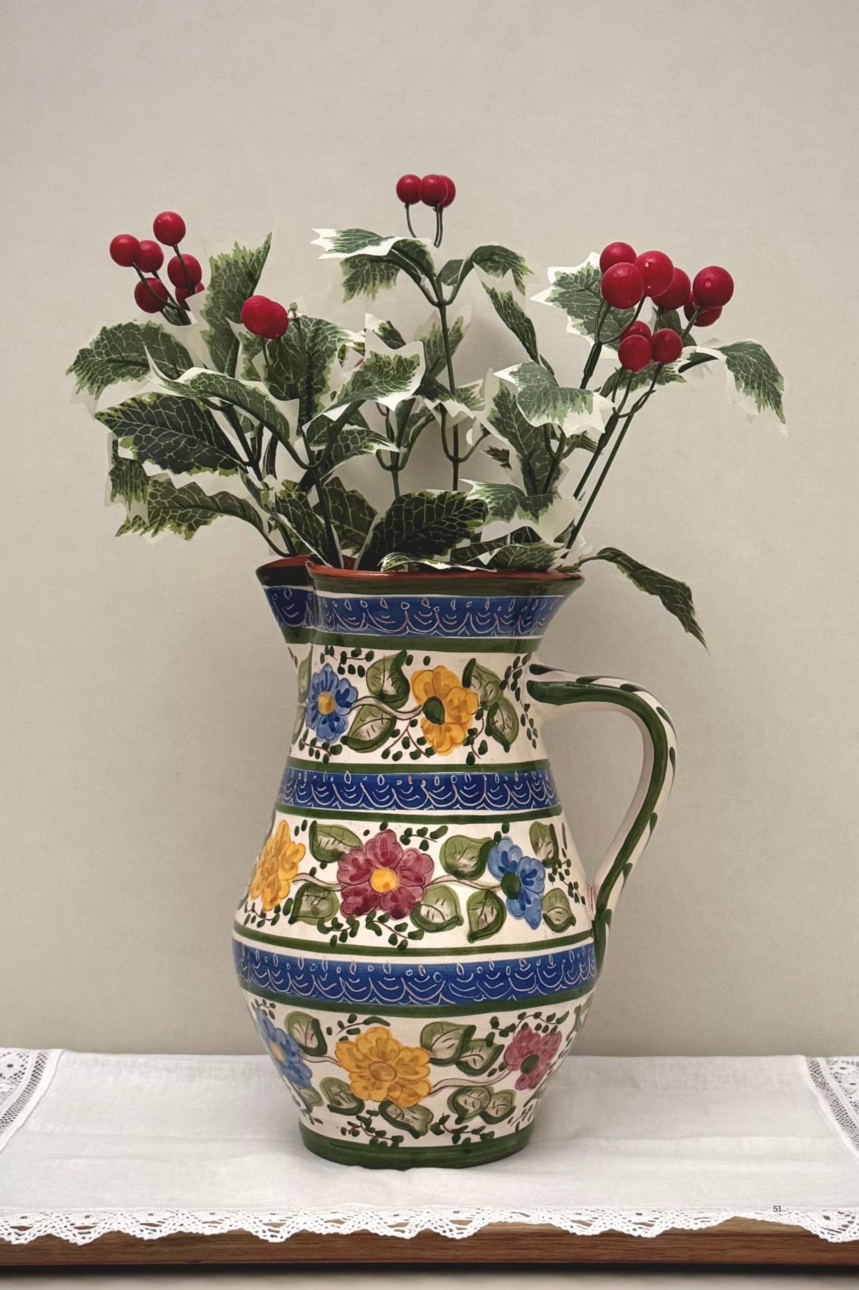 Florinda-clay-jug Florinda Clay Jug – hand-painted Portuguese ceramic with floral motifs in blue, yellow, pink, and green, crafted by artisans and used as a decorative vase.